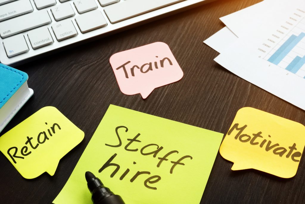 Staff hire, train, motivate and retain written on a memo sticks. HCM, Multiable HCM, ERP system in Singapore