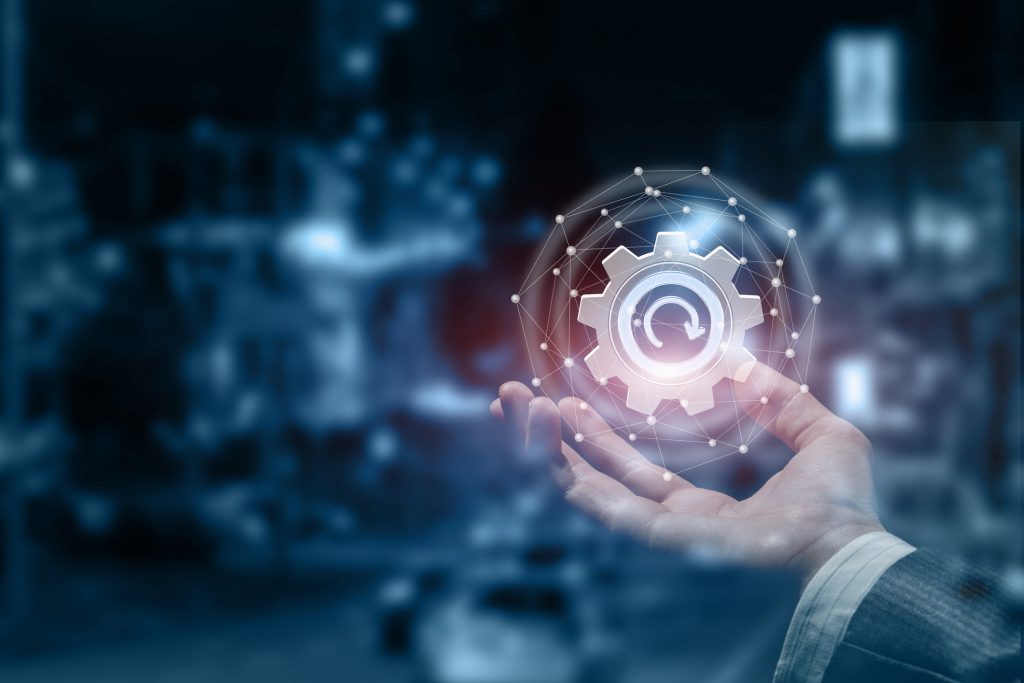 A male hand with an update cogwheel inside a digital sphere.