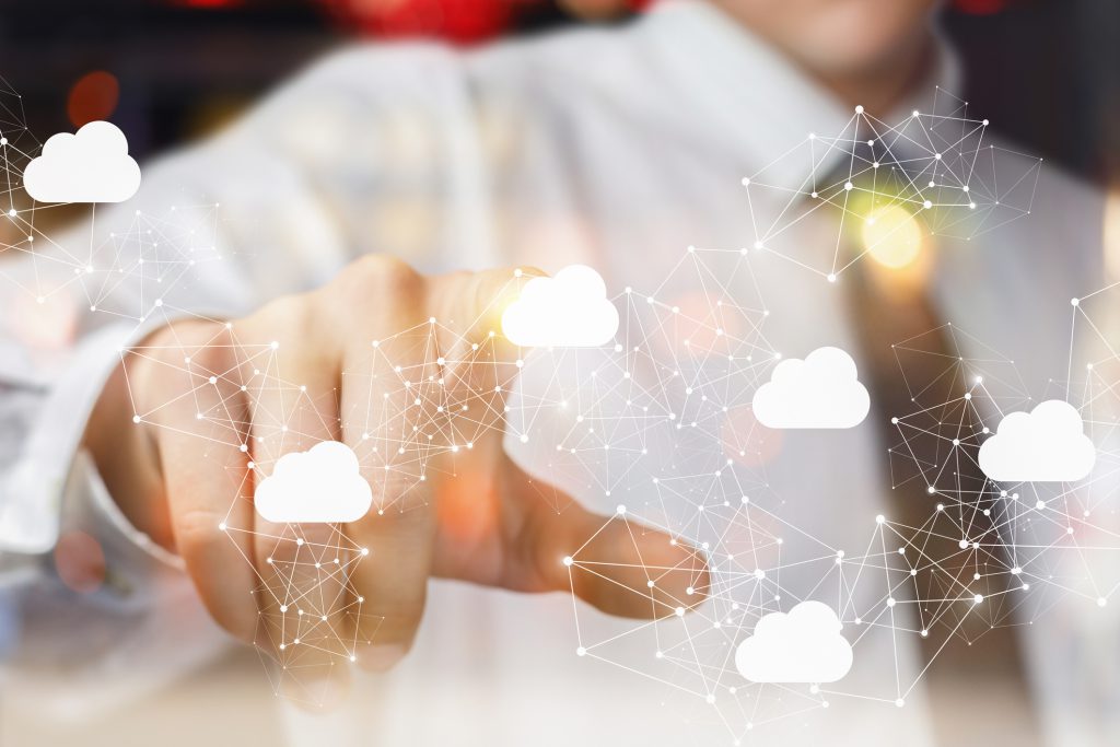 The businessman clicks on the cloud in network . Hidden Economic Benefits of Cloud ERP
