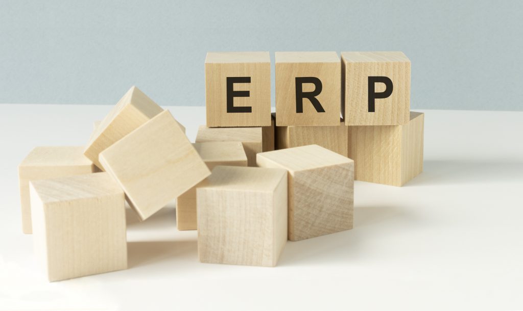 ERP abbreviation made of wooden cubes and office stationary 4 Ways Small Business Can Benefit From ERP