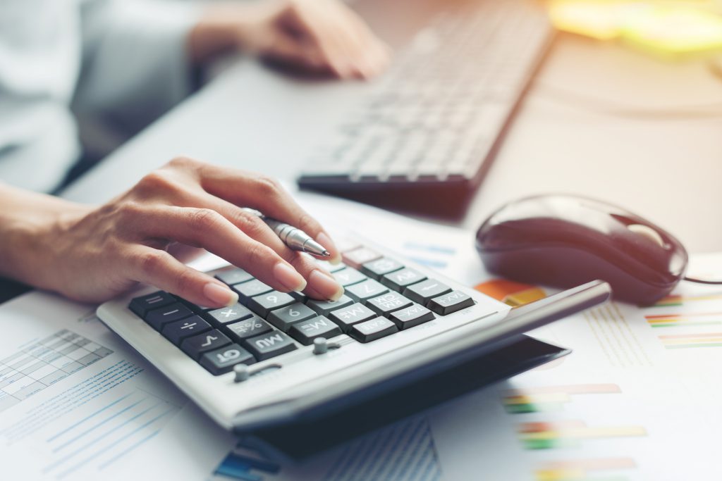 hand of business woman making calculations to control ERP Implementation Cost hand of business woman making calculations to control ERP Implementation Cost, ERP(Enterprise Resource Planning) System in Singapore